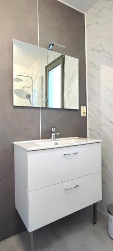 une salle de bain avec un lavabo blanc et un miroir dans l'établissement La Petite Cassagne, à Saint-Geniès