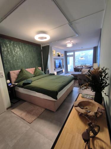 a bedroom with a large bed and a living room at Harz High End Fewo Nicholas 4 Sterne DTV in Goslar