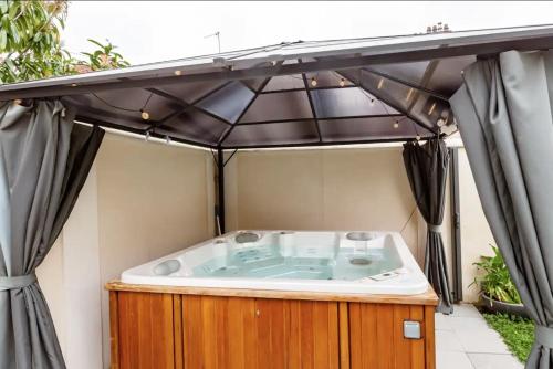 a jacuzzi tub sitting under an outdoor tent at Studio indépendant avec Jacuzzi in Sartrouville
