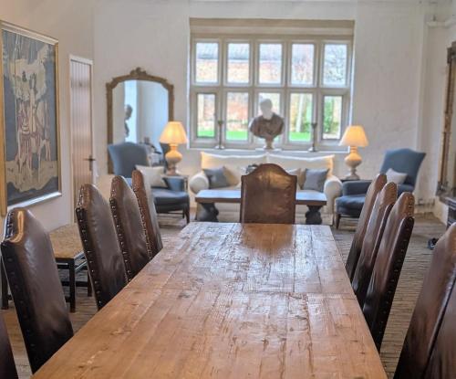 a dining room with a long wooden table and chairs at Five Star Luxury - Oxnead Hall in Burgh next Aylsham