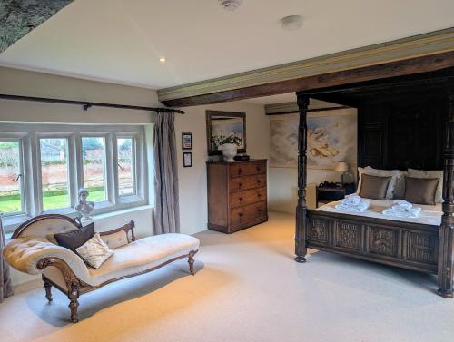 a bedroom with a bed and a couch and a window at Five Star Luxury - Oxnead Hall in Burgh next Aylsham