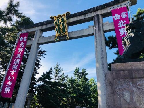 a gate to a shrine with pink banners at 京町家-椿庵Kyomachiya-Tsubakian in Kyoto