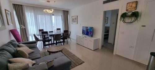 a living room with a couch and a dining room at Savyon View Royal Suites - Alefimmoed in Jerusalem