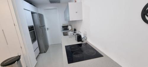 a kitchen with white walls and a black counter top at Savyon View Royal Suites - Alefimmoed in Jerusalem