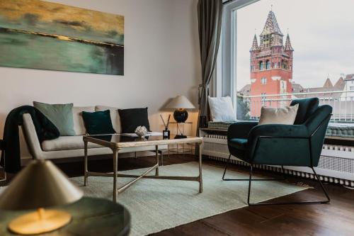 a living room with a couch and a table and a window at The Penthouse Basel in Basel
