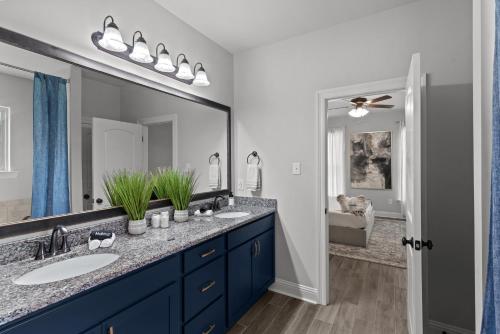 a bathroom with two sinks and a large mirror at Aurora Haven - TV in each room in Shreveport