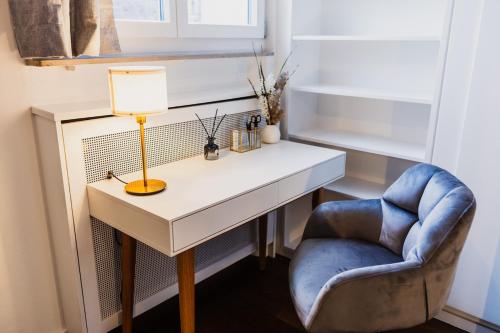 a desk with a lamp and a chair in a room at The Penthouse Basel in Basel