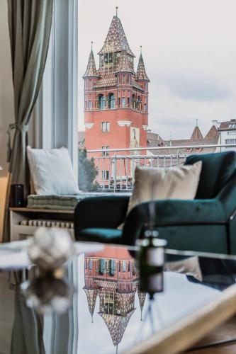 a living room with a view of a building from a window at The Penthouse Basel in Basel