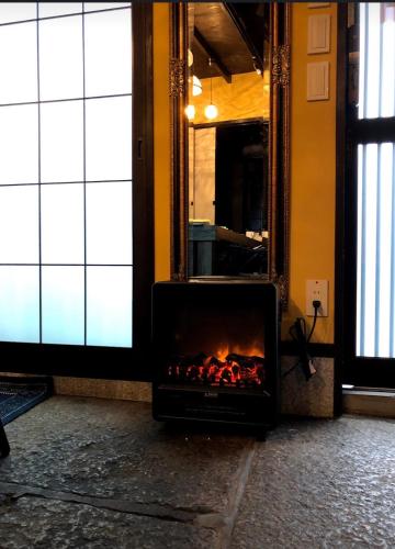 a fireplace in a room with a fire in it at 京町家-椿庵Kyomachiya-Tsubakian in Kyoto