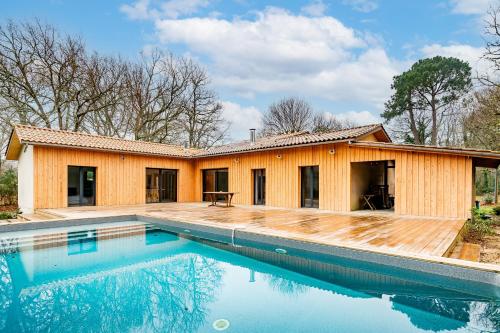 une maison avec une piscine devant dans l'établissement Le Bois de la Hutte - Piscine privée, à Grayan-et-lʼHôpital
