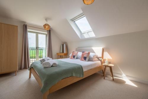 a bedroom with a bed with a skylight at Kingfishers Cove 4 in Titchwell