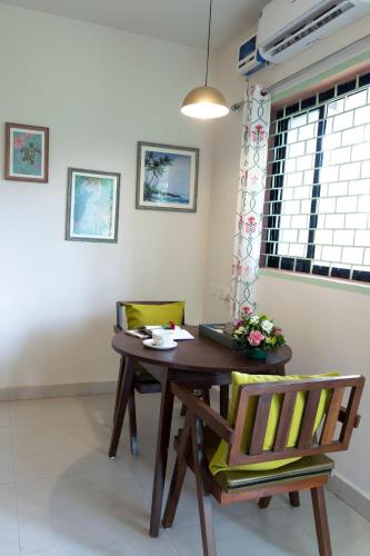a dining room with a wooden table and two chairs at Baba Au Rhum Cafe & Stay in Morjim