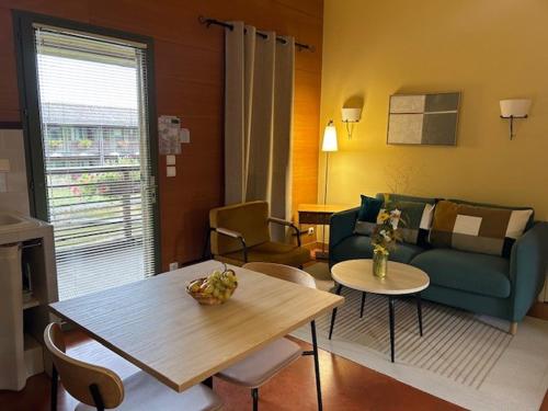 a living room with a couch and a table at Résidence Les Vignes in Jonzac