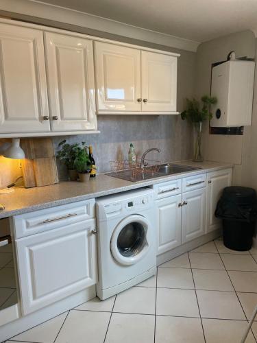 a kitchen with a washing machine and a sink at Signal Rest in Swindon