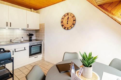una cucina con un tavolo e un orologio a parete di KleineMuschelbude a Dornum