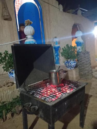 a table with a pot in a room with vases at Dar alibaba in Douz