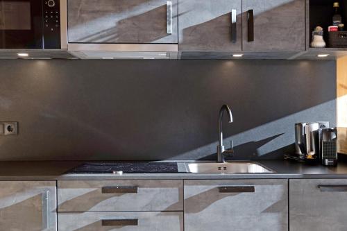 a kitchen with stainless steel cabinets and a sink at Chalet Berg in Selva dei Molini