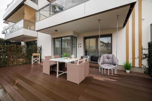 a house with a deck with a table and chairs at Rezydencja Merwede Aparthotel - My Rest in Gdańsk