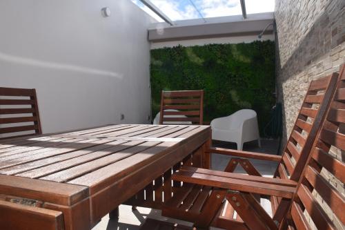 un patio con una mesa de madera y 2 sillas en La Terraza del Faro, en Mazo
