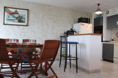 une cuisine avec une table, des chaises et un réfrigérateur dans l'établissement Appt 2 pièces ILE DE RE IDR400-002, à Saint-Martin-de-Ré