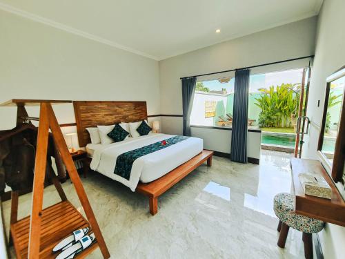a bedroom with a bed and a large window at Sejati Villas - Petitenget in Seminyak