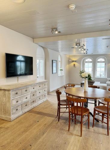 a dining room with a table and a tv at Hotel Hirschen am See in Meilen