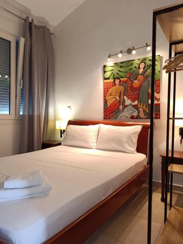 a bedroom with a bed with a painting on the wall at Iraklitsa Teo Resort in Iraklitsa