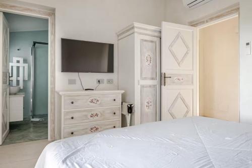 a bedroom with a bed and a tv on a dresser at VILLA AMIRA Porto Cervo con vista Mozzafiato sul Mare,Piscina Privata,WELLNESS & SPA in Liscia di Vacca