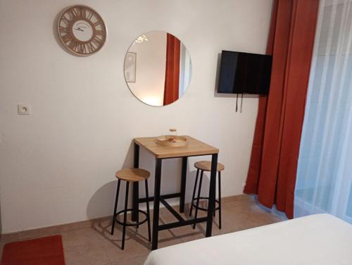 a small table in a room with a mirror and stools at B010 Appartement Disneyland Paris France in Montévrain