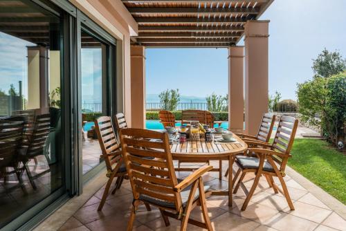 a dining room with a table and chairs on a patio at Villa Kalida, Stunning Seaview and Relax in Mati