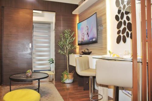a living room with a table and a tv at Air Residences-Stylish&Comfort Stay High flat with balcony in Manila