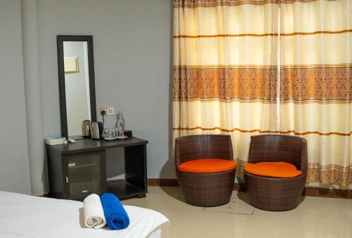 a room with two chairs and a desk and a mirror at Nika Inn Himandhoo in Himandhoo 