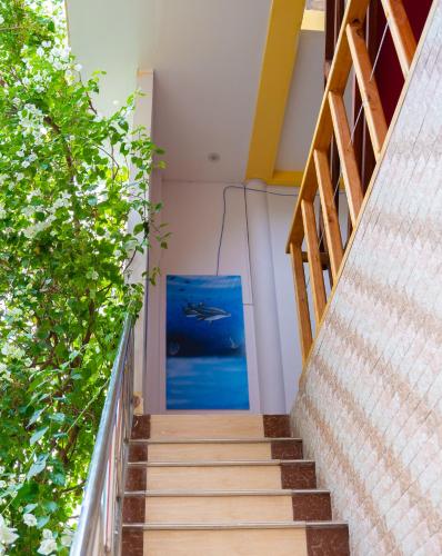 a staircase leading up to a house with a painting at Nika Inn Himandhoo in Himandhoo 