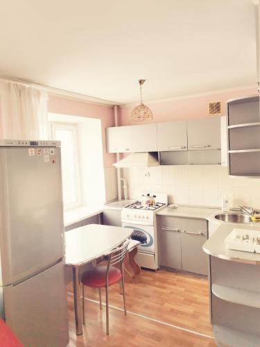 a kitchen with white appliances and a table in it at 2 комн квартира в центре по Пушкина in Kostanay