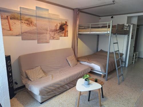 - un salon avec un canapé et des lits superposés dans l'établissement Appartement studio-cabine 6 Couchages Cap-D'Agde, au Cap d'Agde
