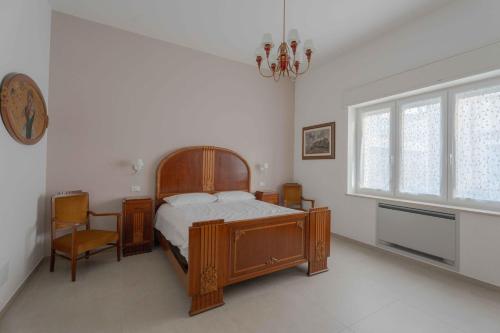 Un dormitorio con una cama y una silla y una ventana. en Villa Magliese, en Maglie