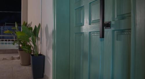 a green door with two plants in a room at Marvic House in Exaplátanos
