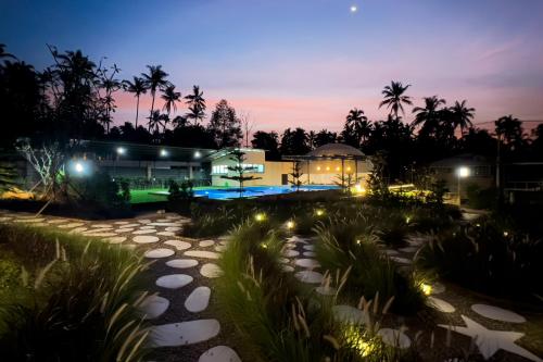 a resort with a building and a swimming pool at night at Sunny Side Resort Koh Tao in Koh Tao