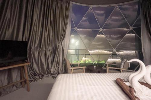 a bedroom with a bed and a window with swans at Sunny Side Resort Koh Tao in Koh Tao