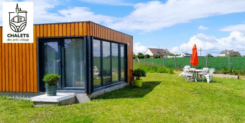 ein kleines Haus auf dem Rasen mit einem Tisch in der Unterkunft Chalets des prés-village in Bussy-le Repos