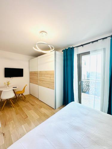 a bedroom with a bed and a table and a tv at Central Grand Apartment in Timişoara