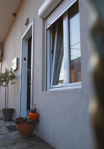 a window on the side of a house with plants at Marvic House in Exaplátanos