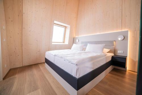 a bedroom with a large white bed with a window at Summit of Saxony Resort Oberwiesenthal in Kurort Oberwiesenthal