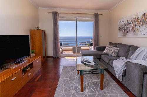 a living room with a couch and a television at Apartamento Vista Azul in Funchal