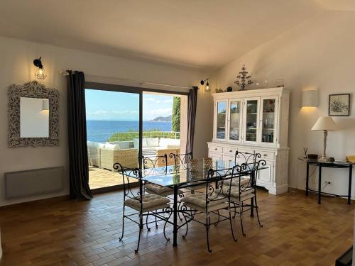 une salle à manger avec une table et des chaises en verre dans l'établissement Très belle villa accès mer et vue panoramique, à Porto-Vecchio