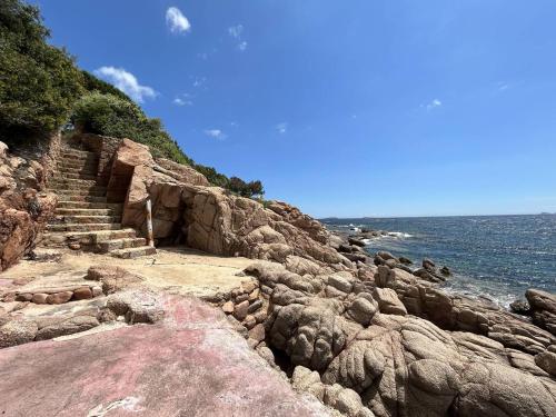 - un escalier sur une falaise rocheuse à côté de l'océan dans l'établissement Très belle villa accès mer et vue panoramique, à Porto-Vecchio