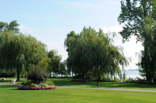 a park with trees and flowers in the grass at Chateau Vaudreuil in Vaudreuil-Dorion