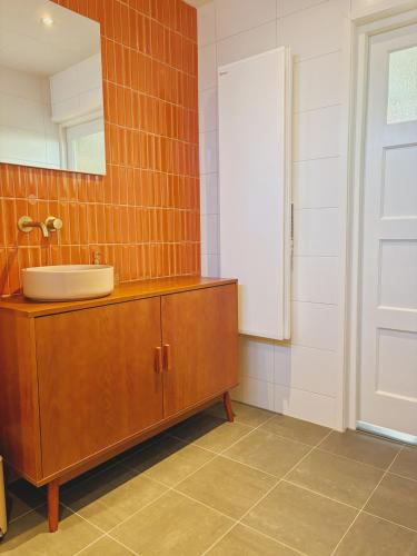 a bathroom with a sink and a mirror at Bungalow Doris met Hottub | 4 personen - Vakantiepark De Kremmer in Gasselte