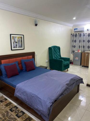 una camera da letto con un letto e una sedia verde di Studio apartment a Ikeja