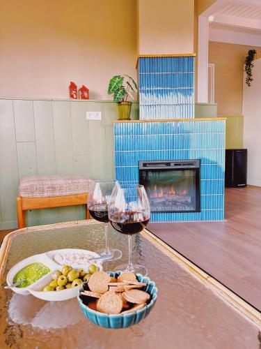 a table with two glasses of wine and a tray of food at Bungalow Doris met Hottub | 4 personen - Vakantiepark De Kremmer in Gasselte